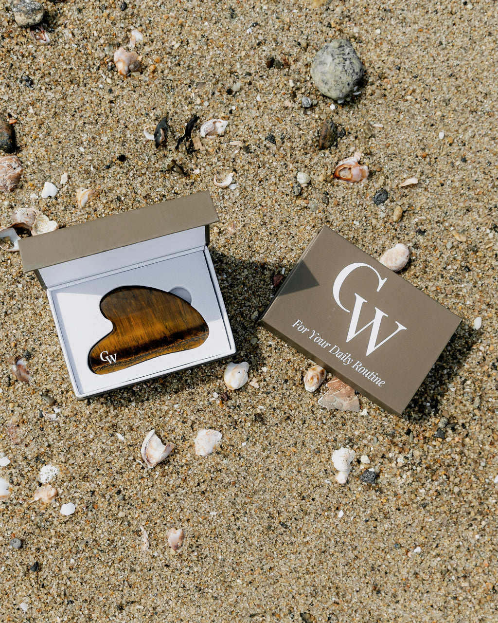 Tiger’s Eye gua sha facial massage tool for sculpting and skincare inside of the brown storage box