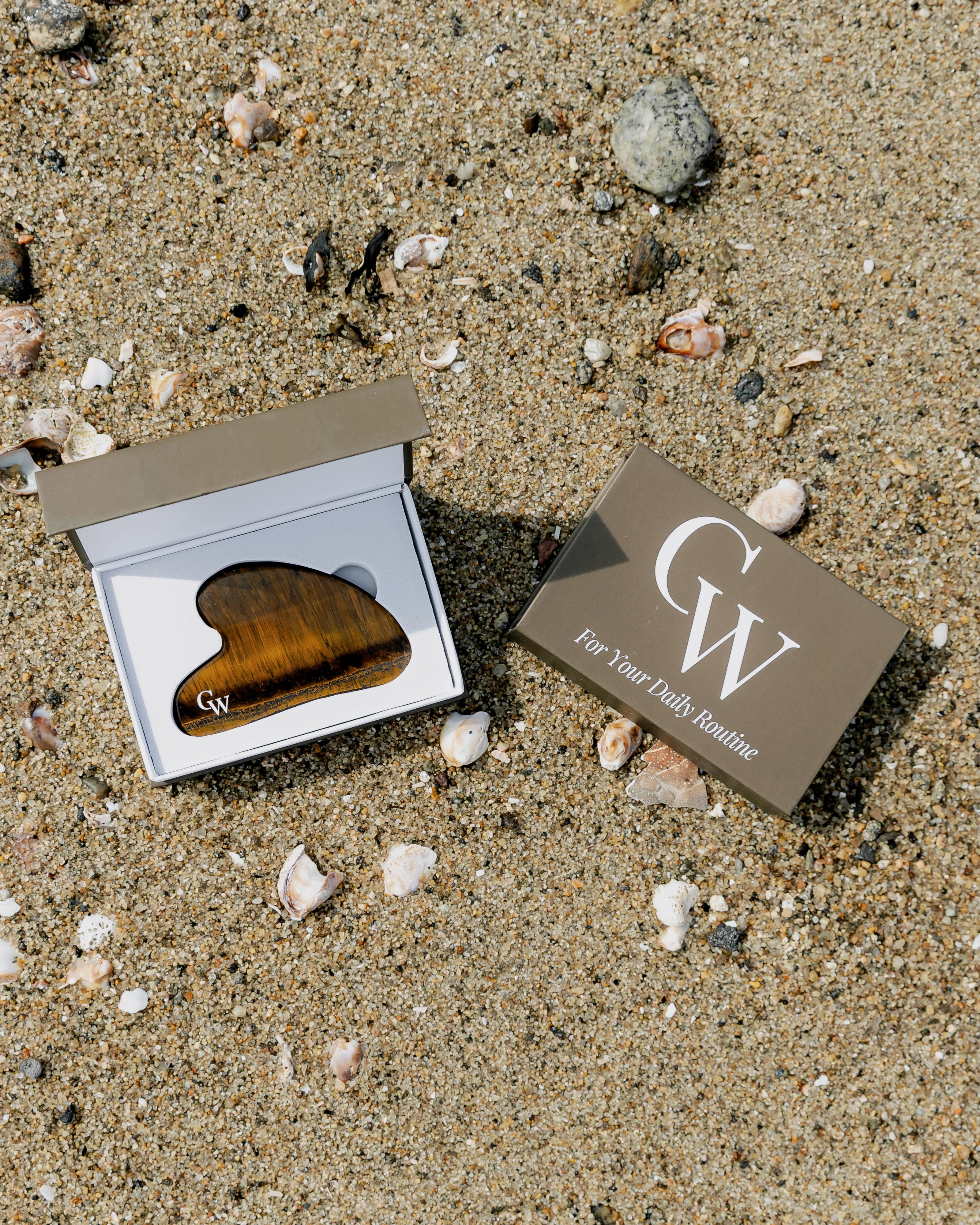 Tiger’s Eye gua sha facial massage tool for sculpting and skincare inside of the brown storage box