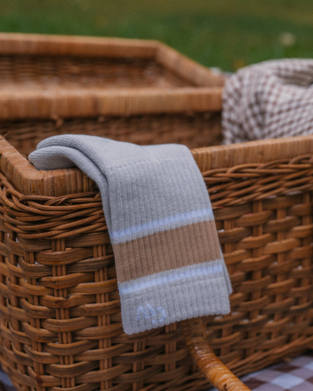 The Grip Socks in Varsity draped over a picnic basket