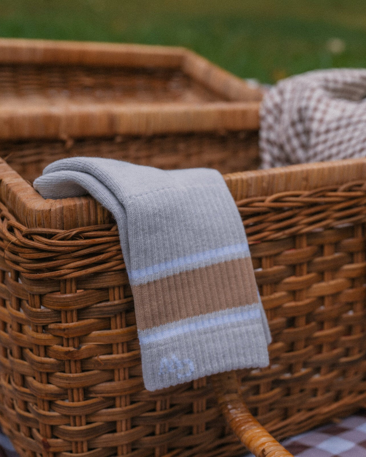 The Grip Socks in Varsity draped over a picnic basket