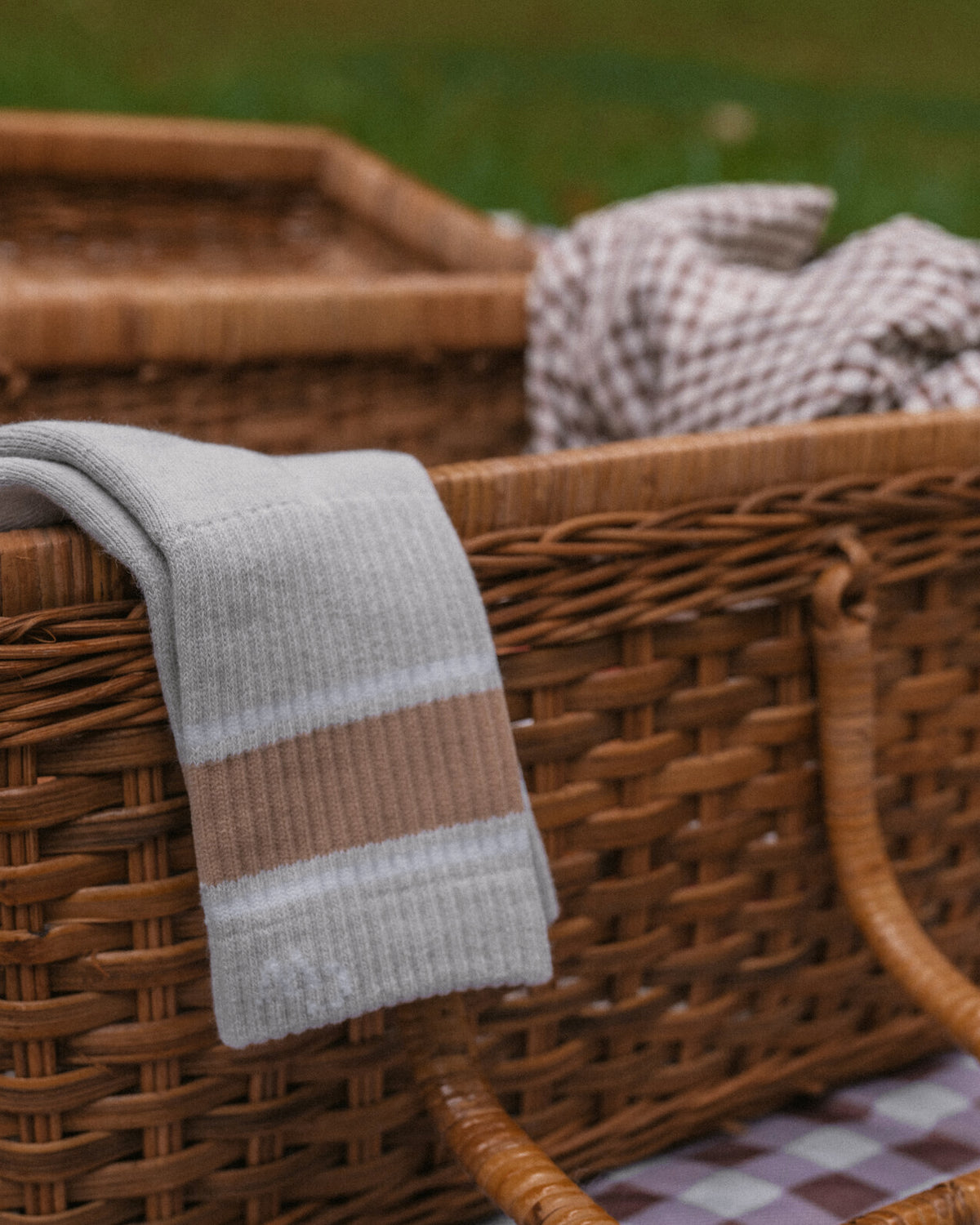 The Grip Socks in Varsity draped over a picnic basket